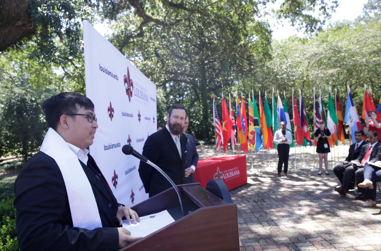 A graduating student speaks at an international student graduation for the University of Louisiana at Lafayette