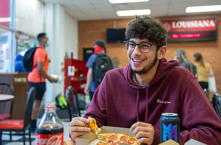 UL Lafayette student eating at University dining area.
