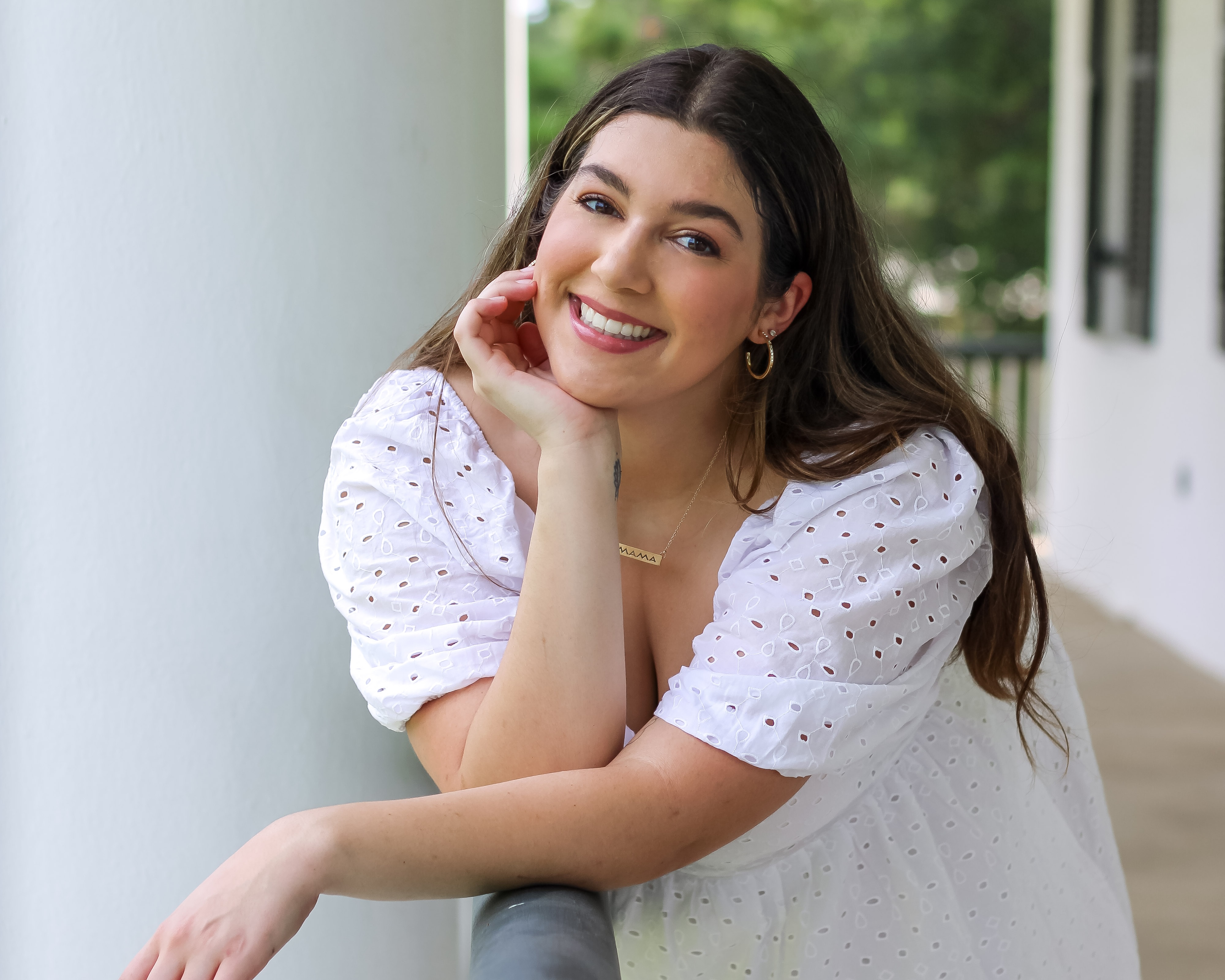 Haley Fisher is pictured outdoors in a white dress. Haley earned her degree in health promotion and wellness online.