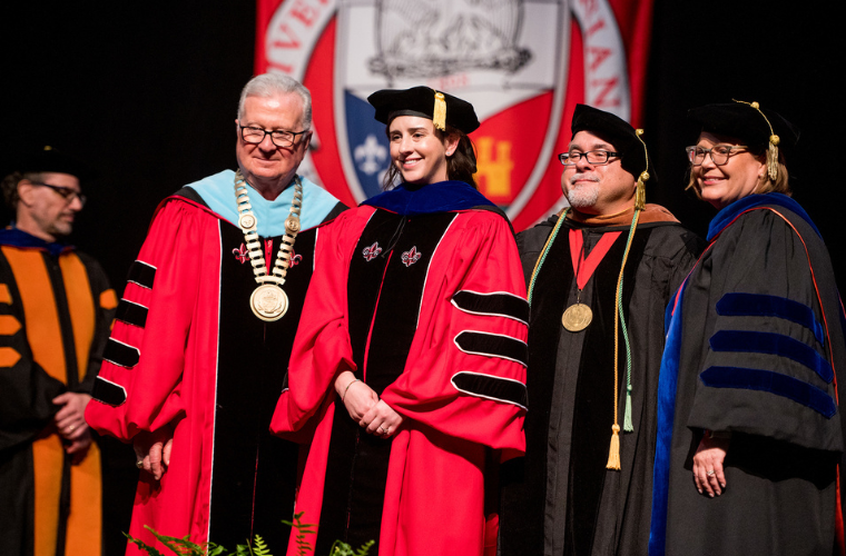 President Savoy and a new Ph.D. student posing at the Doctoral Hooding Ceremony 