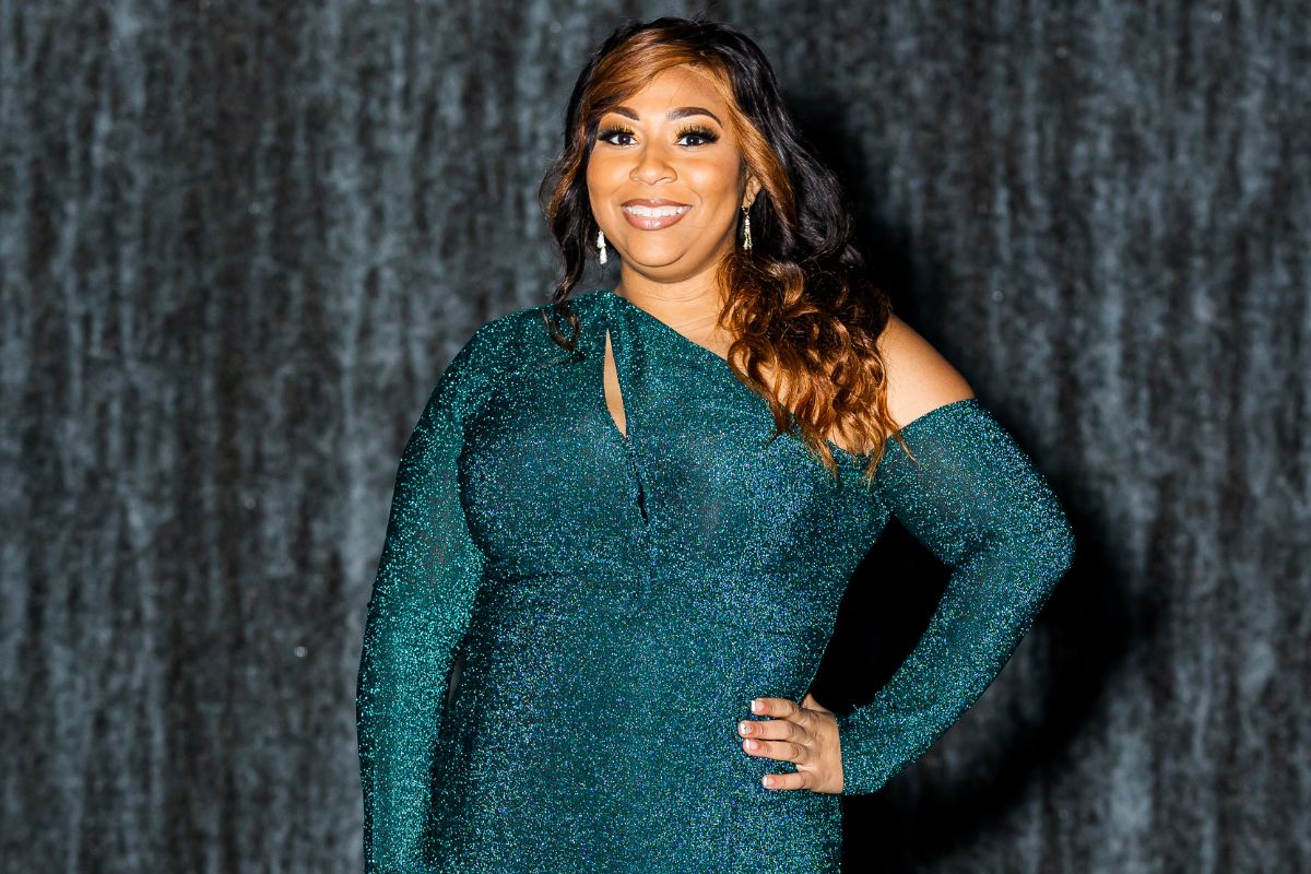 Halle' Castille, wearing a sparkly teal dress, poses for a photo in front of the Hilliard Art Museum at the University of Louisiana at Lafayette.