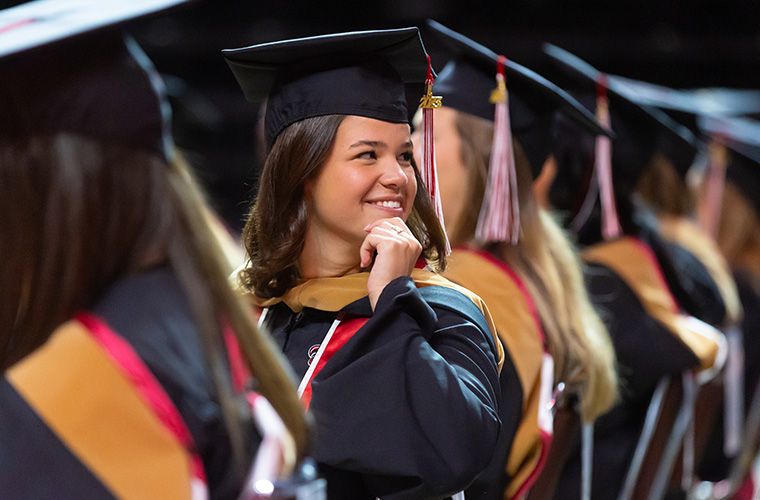 UL Lafayette Student in cap and gown at graduation ceremony.