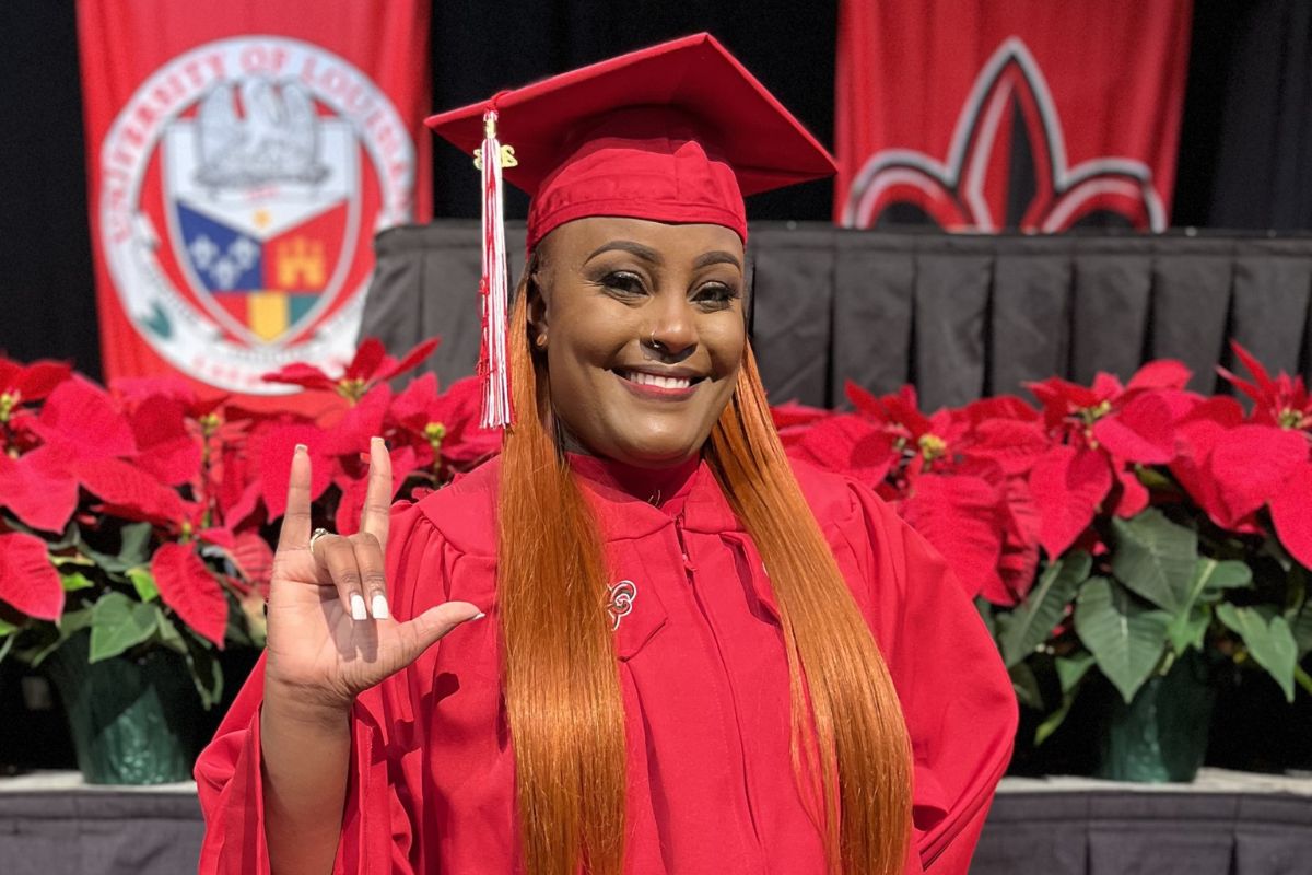 Latasha Cooper, 2023 graduate of UL Lafayette's online RN to BSN program, smiles and holds up the U-L hand sign at Commencement.