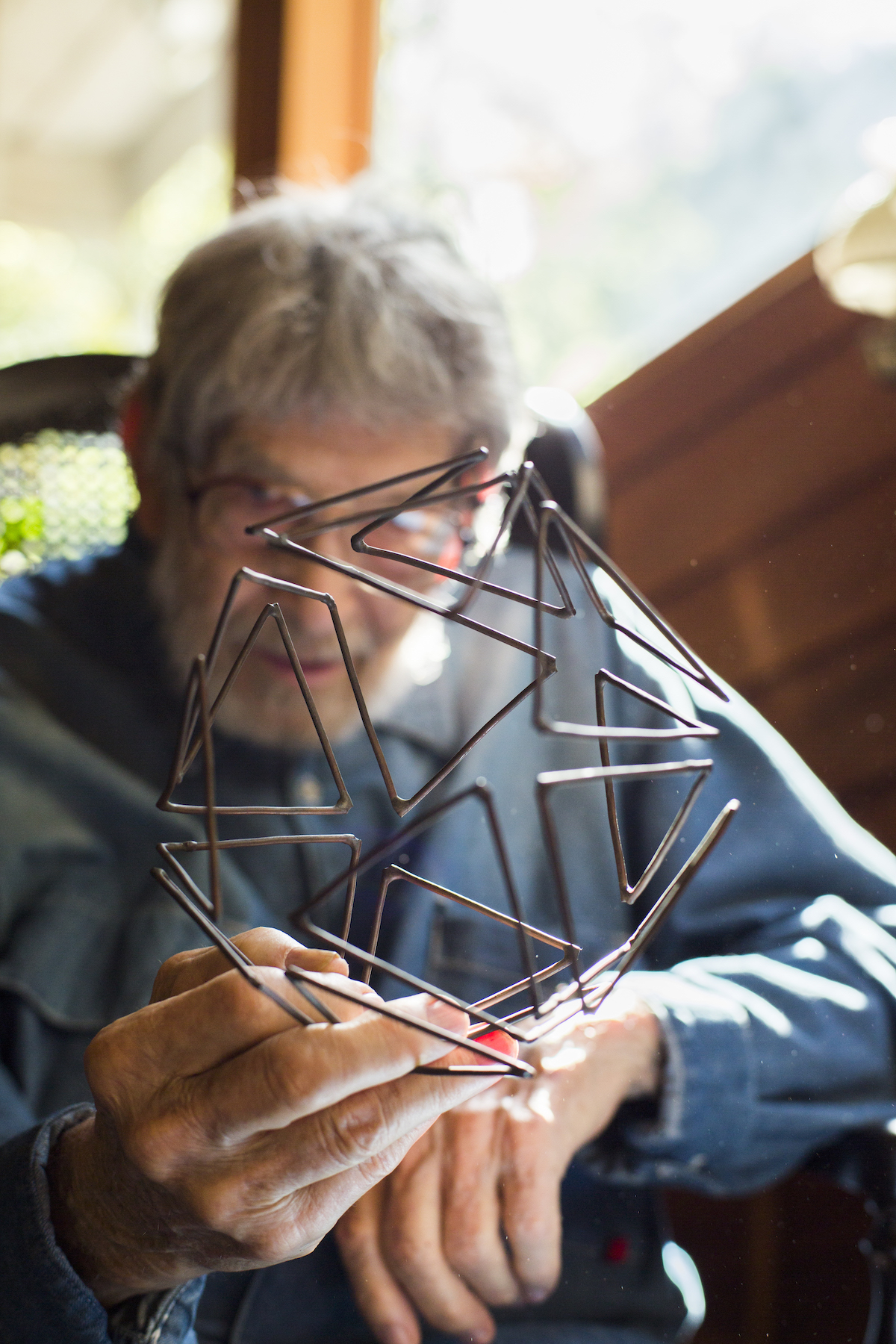 Former professor Robert Wiggs holds one of his sculptures.