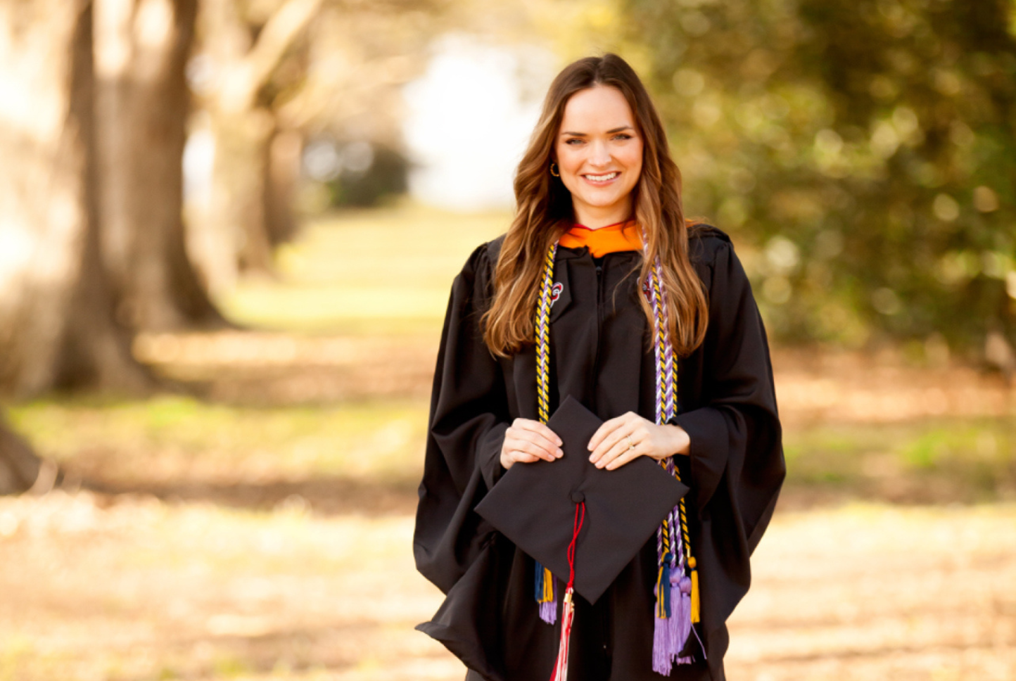 Audrey Reeves is pictured outdoors in graduation regalia. Reeves earned her MSN degree online through UL Lafayette.