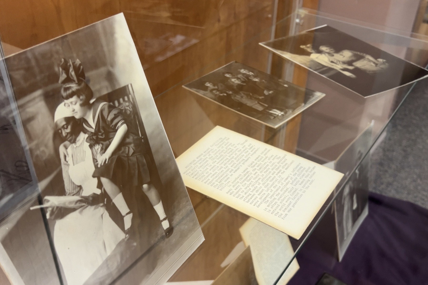 Black-and-white archive photographs in an exhibit case.