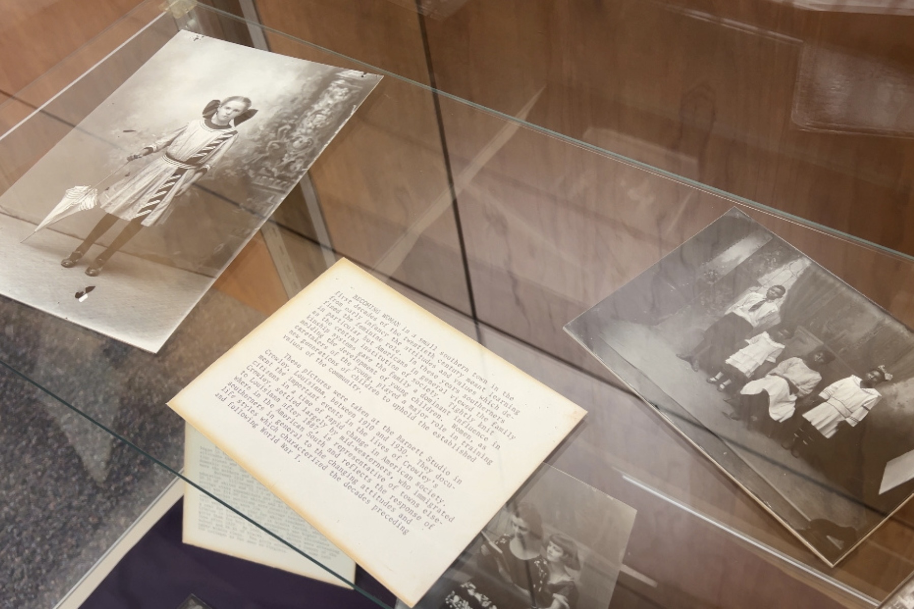 Black-and-white photographs and caption card in a display case.