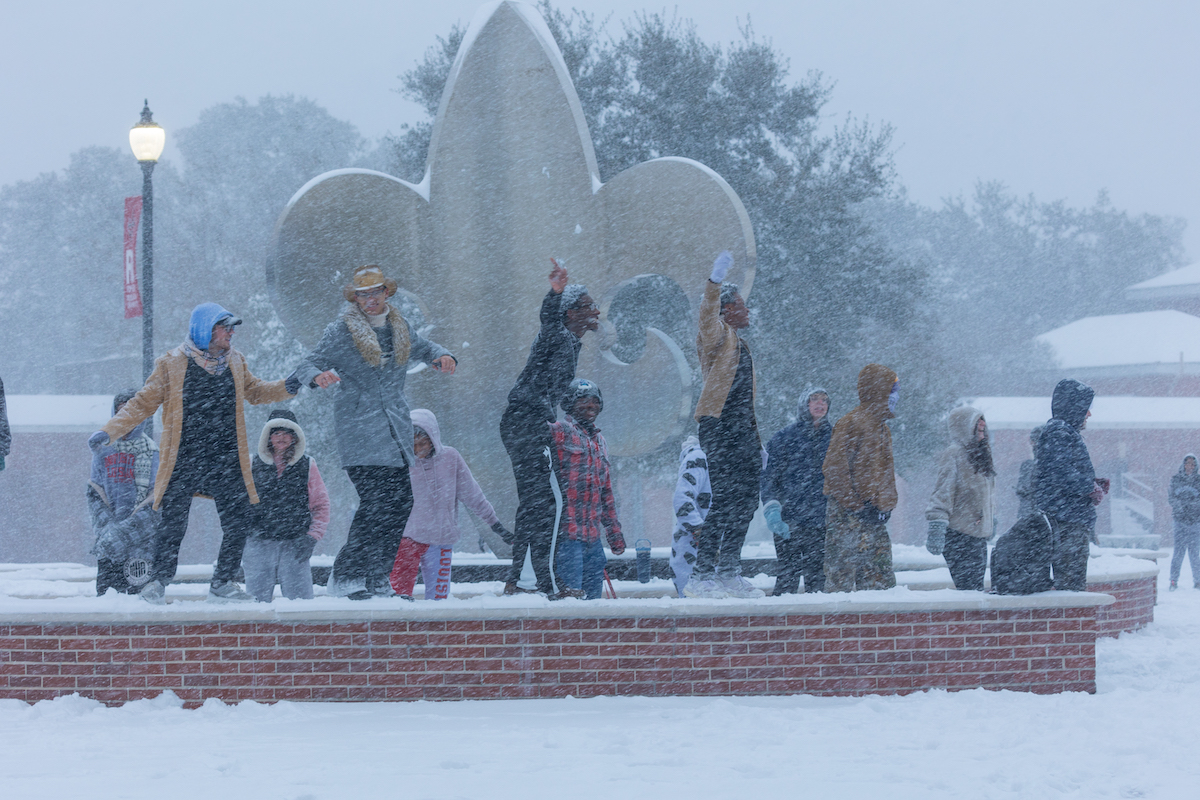 Student dance on the fleur des lis fountain in the quad during the blizzard of 2025.