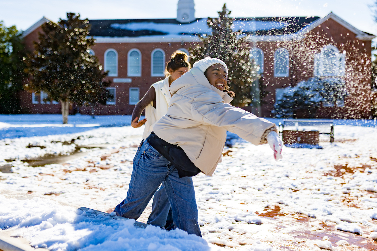 A girl throws a snowball in front of Stephens Hall following the historic 2025 blizzard.