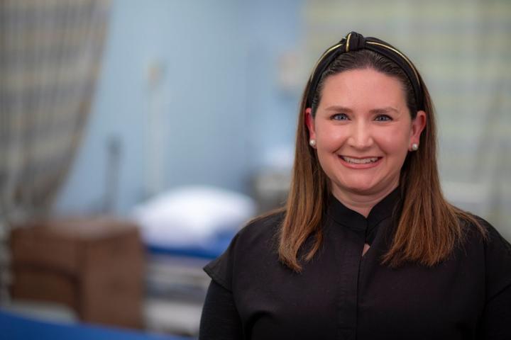 Dressed in black scrubs, Brandy Sizemore poses for a photo while working in a clinic.