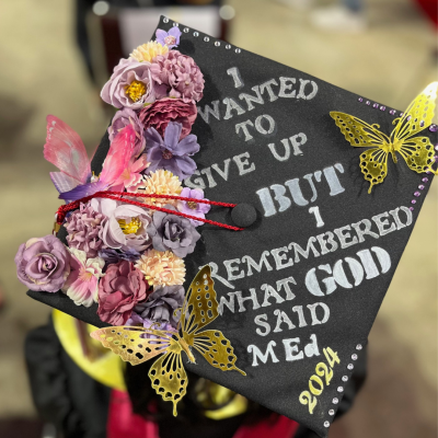 A graduation cap is decorated so that on the top it reads, "I wanted to give up but I remembered what God said. M.Ed. 2024."