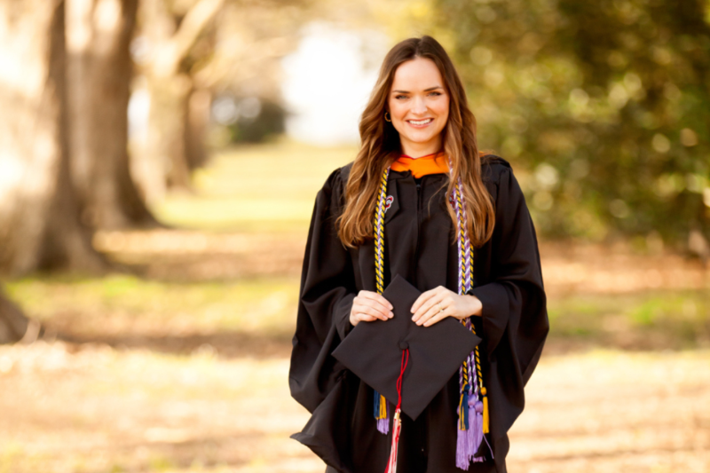 Audrey Reeves is pictured outdoors in graduation regalia. Reeves earned her MSN degree online through UL Lafayette.