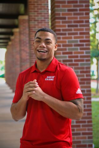 Jonte Morrison standing with his hands clasped wearing a red, UL Lafayette polo.