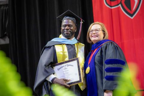 Kreig Trigg, M.Ed. in Educational Leadership graduate, accepts his degree from Dean Mary Farmer-Kaiser.