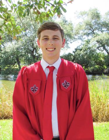 Photo of Kyle Burnam in his red commencement gown