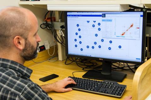 A biotechnologist reviews data on a computer. Biotechnology is a growing field in need of informatics professionals.